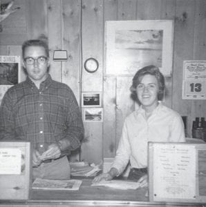 A young couple at the time, Bruce and Sue at the front desk of Gunflint Lodge, open and ready for business.