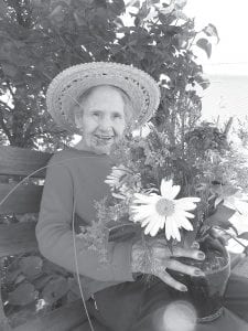 Left: Trudy Boyd proudly displays the floral arrangement she made for the Grand Marais Garden Show held on July 22. Trudy entitled her bouquet In The Garden. Thanks to Diane Nowers (our Care Center “Flower Lady”) for donating the flowers. Above: Lu Pettijohn was “Queen” for the day when she celebrated her 103rd birthday on July 13 with family and friends.