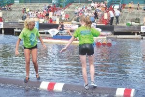 Top: On the left, Paige Everson concentrates on the feet of Claire Keech of Hudson, Wisconsin in the girls’ U-13 amateur championship log rolling match at the Hayward Lumberjack World Championships. Left: A happy group of North Shore Rollers displays their winning plaques. (L-R) Paige Everson, Ali Duclos, Dominic Wilson and Taylor Everson.