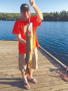 Left: Jeff Reichenback from Chicago caught this 38-inch northern right off the dock at Hungry Jack Lodge on Hungry Jack Lake on July 26. He released the big fish.