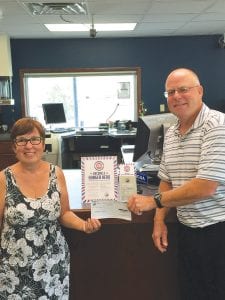 Beth Kennedy, representing the Snacks and Packs program, happily accepts a donation to fight hunger from North Shore Federal Credit Union President Mark Summers. The money comes from credit union members participating in the Hunger Hero program.