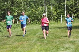 Above: Keeping up an old tradition, the Ratelle family came from Stewartville, Minnesota to take part in the trail run. After finishing their race, the men joined Christine to cross the finish line as a family. (L-R) Jakob, Jim, Christine and Jadon. Right: Emma Spoon sprints to victory. Middle right: Looking strong, Joey Chmelik placed second overall. Far right: Cecelia Chmelik ran 6:45 for the mile.