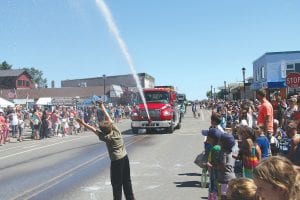 It got hot along the route during the Fisherman’s Picnic parade on Sunday, August 7. The crowd—especially this young man—appreciated getting sprayed by the Grand Marais Fire Department. See more Fisherman’s Picnic fun Hamiltonon pages B6-B7. Marais