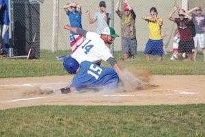 Throwing up a lot of dust, Casey Everson (No. 15) tried to slide under Travis VanDoren’s tag at home plate.