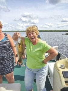 Above: Lois Sprinkle, fishing with her daughter Marcele Spitz and her grandson Jonathan Spitz, celebrates a nice catch at an area lake last weekend. The Indianapolis, Indiana family rounded out their day of fishing by also catching a walleye and a northern.