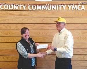 Mike Carlson, the Grand Marais Lions Club president, delivers a check to Betsy Blaisdell of the Cook County Community YMCA for $1,000 to support the YMCA scholarship program.