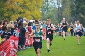 Top: Leif Anderson (No. 3284) put everything into his sprint to the finish line at the Milaca Mega Meet held last Saturday on a soggy Milaca golf course. Anderson finished the 5K (3.1 miles) in 19 minutes and 56 seconds. (L-R) Aurora Schelmeske, Molly Thomas and Chloe Blackburn all ran well at Milaca, the largest high school cross country meet in America, if not the world.