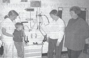 With the recent conclusion of another successful golf scramble, North Shore Health Care Foundation Executive Director Karl Hansen shared this March 6, 1995 News-Herald photo showing the project which was the very first to benefit from the Foundation’s efforts – an infant resuscitation table. In the photo, from left, are nurse Gayle Brett supporting Jeffrey Fenwick, whose newborn brother Luke is seen demonstrating the table, and Jean Ljungkull and Suellen Kruse, members of the Foundation looking on. Hansen noted that Jennifer and Bob Fenwick, the boys’ parents, participated in this year’s tournament along with Jeff, although Luke was unable to attend. Five thousand dollars was donated to the hospital to help pay for the new equipment, which was capable of many functions including warming, examinations, X-rays, oxygen administration, and monitoring of circulation, respiration and heart rate.