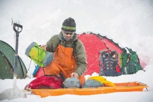 Lonnie Dupre works on his gear in the mountains of Nepal. Dupre is leading a group of climbers up Mount Langju, a 20,000-foot peak in the Himalayas that has never been climbed before. As they climb, he and his fellow mountaineers will collect snow samples for scientists to test for micro pollutants, as well as volunteer and work with the Rose International Fund for Children when they are off of the mountain.