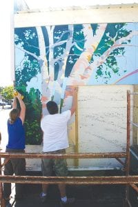 This playful, colorful paint-by-number mural was designed by Mila Horak (right) and painted by the public during the Arts Festival on the Grand Marais Library lawn. Horak and friends installed the 12 panels on the north wall of Birchbark Books and Gifts mid-September. Funds ($1,250) to make and install the mural came from the 2016 Great Place Project (GPP). Sawtooth Clinic’s Moving Matters and the Cook County Chamber of Commerce sponsor the GPP. Both the Minnesota Power Foundation and the Cook County Community Fund contribute money to GPP. The definition of a Great Place is that it is inviting, beautiful, eye catching and reflects the unique character of the community. Mila’s mural seems to hit on all of those categories. So far a lot of people have been seen stopping and spending time looking at and enjoying the sweet, whimsical painting.