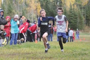 Above: Showing a lot of grit, a determined Tate Crawford came from way back to blow by this Moose Lake Rebel runner with an amazing sprint down the homestretch of the Polar League conference meet held at Pincushion on Wednesday, October 12. Results of the conference meet will be posted in the newspaper next week. Left: In the foreground, Jack Viren steadily moved through the pack in the conference meet.