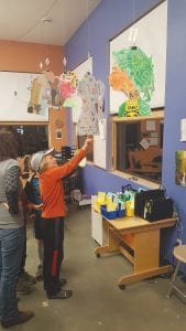 Left: At a recent open house for parents and friends, students at Great Expectations displayed their self portraits (and other art work). The open house also included face painting and a time for the public to join in and make paper bag puppets. Above: Here Silvia Burka shows her plaster mask that she made.