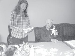 Skip Rouser, right, displays a cornhusk doll she made with the help of volunteer Kay Rosenthal.