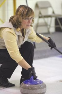 Joanne Smith eyes her next shot, as she gets ready to “curl” the rock down the ice.