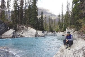 Intrepid explorer Lonnie Dupre, talking on his cell phone, sits comfortably on a ledge of granite in British Columbia while a river fueled by snowmelt flows coolly by. Dupre used his visit to British Columbia to train for his trip to Nepal where he led an expedition to climb Langju, a mountain in the Himalayas. Nearing the summit at more than 18,000 feet, the snow became too risky to walk on, and fearing an avalanche, Dupre led his Vertical Nepal team back down the mountain. The group is still in Nepal working with The Rose International Fund for Children, whose mission is to improve the lives of children with disabilities in Nepal.