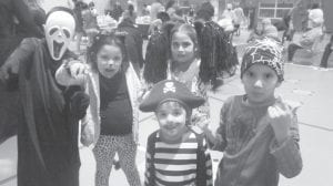 Above: Holly and Uriah Dahl with three of their Canadian cousins at the Halloween Carnival. Left: 92-years-young Doris Blank playing the drums while at a church retreat.