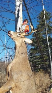 Bear Atkinson posed in this tree with the big buck his father Niel shot last Saturday near Cascade River. The 8-point deer was about 190 pounds, said Niel. The two were on a father-son weekend that involved grouse hunting and fishing.