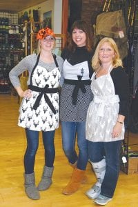 Left: Stone Harbor Wilderness Supply hosted a fashion show for the Storm Fest. Taking part were Gunflint Mercantile owner Chelsea Lueck and her two “apron models.” Top: Looking on in awe are Sophie (left) and Natalie Poliquin. Above (L-R): Kathy Ann Travis shows off her shoes while Emma Spoon displays her new winter hat and outdoor wear.