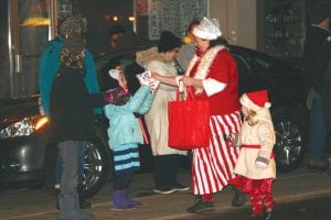 Amber Pfeil and her little helper, daughter Violet, handed out treats during the Christmas parade as part of the group representing Ruby's Pantry.