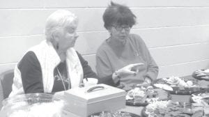 A lot of fun was had at the Elders’ Christmas party. Top: Carol Hackett and Marie Spry priced cookies for the bake sale in Grand Portage. Left: Sisters Polly James and Carol Hackett took a break. Above: Edward Olson raised his hand to say hi to everyone.