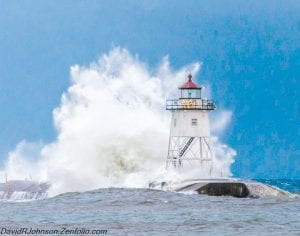 Large waves pummeled the break wall and gave the Coast Guard lighthouse a nice bath last week as high winds from the south kicked up the lake, sending water crashing onto the shore and the road leading to the Coast Guard station. The following day the beach and vegetation bordering the beach were covered in ice, making many opportunities for photographers to take pictures like the one Dave Johnson made for the weather picture on this page.