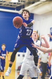 Left: Marcus Logan blew by his defender on the way to the basket in the game against Silver Bay. Logan led the team in scoring with 13 points. Above: Despite Hunter and Weston (15) Monson’s best attempts to block Sam O’Phelan’s shot, O’Phelan rose to the occasion to score two points. The Monson brothers attended CCHS before moving to Silver Bay several years ago.