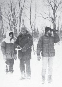 The most important—and perhaps coldest— job during a sled dog race belongs to the time keepers. These hardy (but unknown) souls are shown keeping watch (and times) during the Grand Portage Training and Nutrition Race held in Mineral Center on Dec. 12, 1981. Seventy teams from all over Minnesota, Wisconsin and Ontario participated in the one-day event.