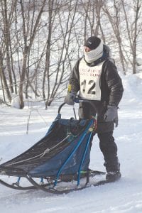 Above: Chad Schouweiler of the Otter Run Kennel was the 2017 winner of the 8-Dog Race at the Gunflint Mail Run. Left: A team of happy dogs pulling her sled, Joanna Oberg of the Run Silent Racing Kennel placed second in the 8-Dog Race.