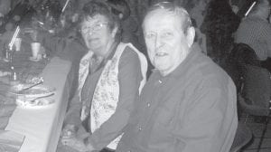 Above: Bob and Eddie Hertzberg enjoying the Christmas party. Left: Carol Hackett and Sally Gagnon taking a break from filling community Christmas goody bags.