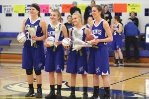 Four seniors were honored at the last home game of the year. Receiving flowers and basketballs were L-R: Emily Jacobsen, Sarah Toftey, Hannah Toftey, and Bayley Cox.