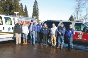 When Lutsen acquired its new EMS truck, it sold its old vehicle to Tofte, who in turn sold its older vehicle to Grand Marais. Two of the three squads and their vehicles got together recently for a picture. The North Shore Health Care Foundation (NSHCF) gave Tofte $7,500 to help purchase the Emergency Medical Service (EMS) vehicle from Lutsen. Pictured from left, Karl Hansen representing the NSHCF, Kim Jahnke, Fred Schmidt, Erik Brunsvold, Pam Swenson, Phil Bonin, Lester Smith, Tim Thoreson.