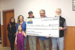 Jan Smith of the Grand Marais PUC, Courtney Quaife, Payton Quaife, Tim Quaife, Karl Hansen, and Tim Kennedy pose with a check detailing the amount awarded to Mike’s Holiday.