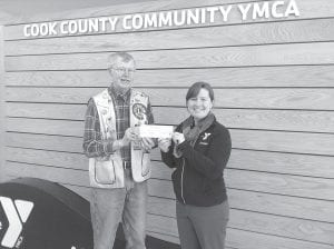 The Grand Marais Lions Club recently made several donations to worthy groups. Right: A $1000 contribution was given to the YMCA Ham Run Fundraiser. “Our scholarship fund supports local youth by providing programs at an affordable rate. Thank you for supporting our community,” said Betsy Blaisdell, YMCA support specialist pictured here accepting the check from Lion President Mike Carlson.