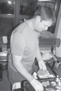 Above Cory Christianson cooks while to his right Mike and Maureen O’Phelan get a tasty treat from staff at Gunflint Mercantile.