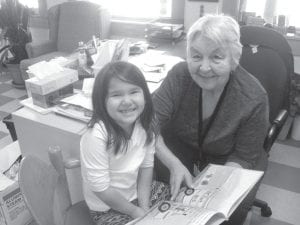 Grand Portage elders often go to the Oshki Ogimaag Charter School and read with the children. Here Carol reads with Talia. Or is it the other way around?