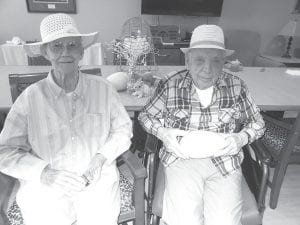 Above: Mary Liebsch and Chuck Norman look pretty “spiffy” in their new Easter bonnets that they won at Easter Bingo on April 13. Left: Helene Smith enjoyed a visit with “Harley,” a 5-day-old goat from the North Forest Farm in Hovland, who visited the Care Center recently.