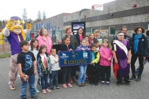 A happy group of kids (and some local dignitaries) proudly held the giant check for $100,000 that will be used to purchase new playground equipment at the Grand Portage Community Center.