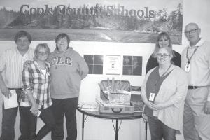 Standing by the time capsule are from left to right: Bruce Johnson, Jana Larson, Pam Taylor and on the other side of the table are Julie Viren, Lorelei Livingston and Scott Steinbach. The capsule was small but held big memories, along with the hopes and dreams of the kids who contributed to it.