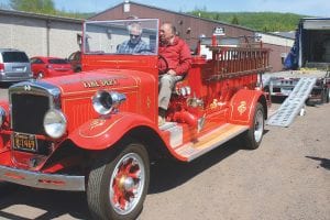 This perfectly refurbished, polished gleaming bright red 1933 International firefighting rig was shipped via freight truck to Steve’s Sports in Grand Marais from Prescott, Arizona on Thursday, June 1. Hank Wamboldt of Prescott donated the truck to the Gunflint Trail Fire Department. Pictured driving the truck is Paul Kelnbereer, treasurer, and Jim Morrison, Gunflint fire chief. The two men drove the truck to Fire Hall 1, which is located mid-trail. On Sunday, June 11 the rig will be driven to Fire Hall No. 3, where it will be on display for the shrimp boil, a fundraiser for the Gunflint Trail Historical Society. The truck is loaded — literally — with all of the bells, axes, ladders, and lights it originally came with.