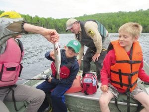 Rebecca Wiinanen is holding the fish admired by Grant Oberg. Minnesota Department of Natural Resources Area Fisheries Supervisor Steve Persons is in the back and Kia Erickson is to the right of Grant.