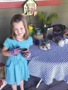 It’s never too early to learn how to grow plants. Above, wearing her finest gardening gloves, future West End Garden Club member Ezme Mundell prepares to plant her favorite flowers.