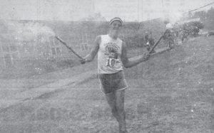 Duluth runner Bruce Bauer celebrates Independence Day 2004 and his completion of the 25th annual Tofte Trek by brandishing some Roman candles at the end of the race. Baur finished third with a time of 39:27, behind Greg Hexum (36:36) and Adam Swank (39:01), both of Duluth. More than 124 runners and 24 walkers took part in the event, jumping and dashing through and over puddles and muddy trails. This year’s race course promises more of the sloppy conditions – bring your old shoes!