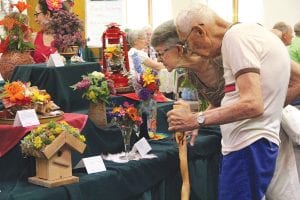 Top: Bernie and Millie Gestel look inquisitively at one of the many dazzling displays at last Saturday’s Grand Marais Flower Show. Above: Linda Quick’s “Blooms of the Southwest” was a big hit at the show for its originality and creativeness. Right: Sombreros provide some shade while two workers take a siesta underneath a dash of sun-splashed daisies. The flower arrangement is called “Mexican Siesta” and was crafted by Nancy Haarmeyer.