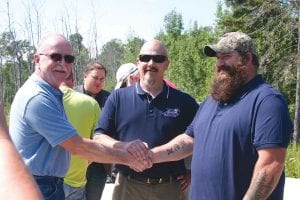 The three men who took part in the sale of the land were L-R: Mike Blood, landowner; Frank Lehto, realtor; and Theo Rex, who will own the property. All three found out that they had military backgrounds and the common bond melded a quick friendship.