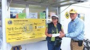 The $10,000 Fisherman’s Picnic Grand Marais Lions Club prizewinner was Geraldine Hunt of Duluth, Minnesota, formerly of Grand Marais. Presenting the check to a happy Geraldine is Lion President Mike Carlson.