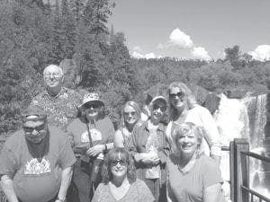 Cook County Seniors took a trip to High Falls in Grand Portage and enjoyed the spectacular scenery. Standing in front left to right are Fred Schmidt, Nancy Dumas and Kim Nelson. Second row, left to right: Tom Hedstrom, Kaye Kraft, Jade Woltmann, Betty Michaud, and Darrellyn Barrett.