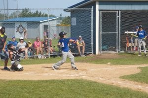 Above: Batter Derek Smith swings for the hit, driving the ball through the infield for a single. Left: Shortstop Morgan Starkey throws to first baseman Cole Anderson for the out. Great team play was the theme for the Vikings as they tied for third place in the tournament.