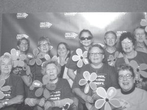 Top: Elders participated in the annual Alzheimer’s Walk for a Cure on Saturday, September 9 in Duluth. Some carried flowers with family members' names. Above: Shirley Stevens and Marie Spry with their Alzheimers's remembrance flowers. Left: Ellen Olson and Carol Hackett at the ENP with the Alzheimer’s remembrance flowers from the walk.