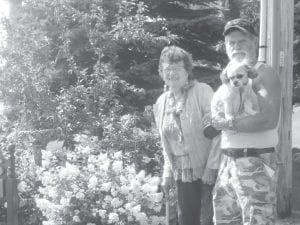 Eddie Hertzberg with Bill Elstad and his puppy visiting his lush gardens.