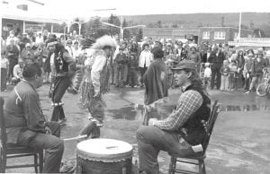 Circa early 1970, Billy Blackwell, wearing a hat, and Rudolph Peterson mark time on the drum with Grand Portage tribal members Lex Porter, Speedy Porter and a young lady whose name has been forgotten, to perform a ceremonial dance for the public at what is believed to be the Fisherman’s Picnic in either 1971 or 1972. Blackwell said a request was made by the Grand Marais Lions Club to have the Band members come to the Picnic and display some of their heritage. Blackwell said the event turned out well and the crowd was appreciative and respectful of the dance and song.